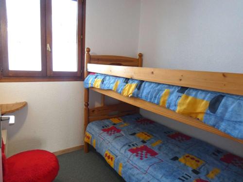 圣拉里苏朗Appartement Saint-Lary-Soulan, 3 pièces, 6 personnes - FR-1-457-243的一间卧室配有双层床和红色椅子
