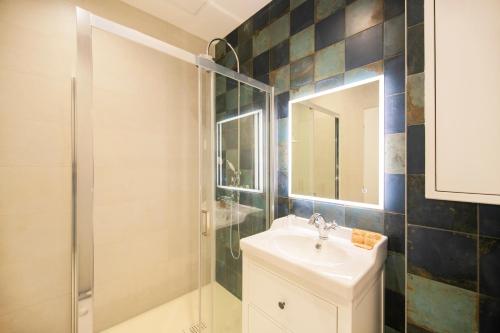 桑斯Le Laurencin Sens - Le Campagne的浴室配有盥洗盆和带镜子的淋浴