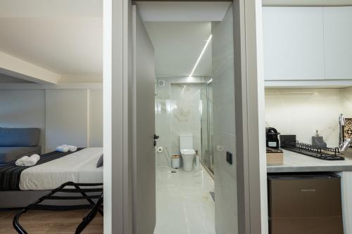 斯巴达Athens Airport Living spaces的一间设有一张床的房间和一间带玻璃门的厨房