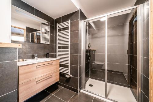 莱热Apartment Clematis Les Gets- BY EMERALD STAY的带淋浴和盥洗盆的浴室