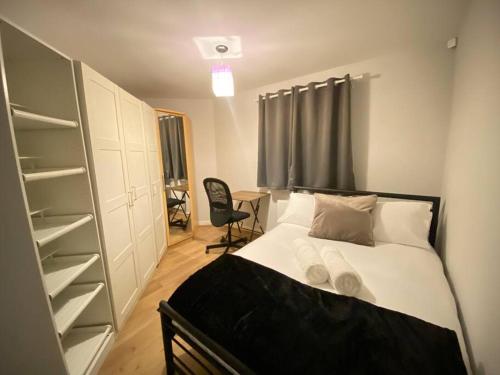 珀弗利特Spacious 2 bed flat ideal for long stays的一间带一张床和一个衣柜的小卧室