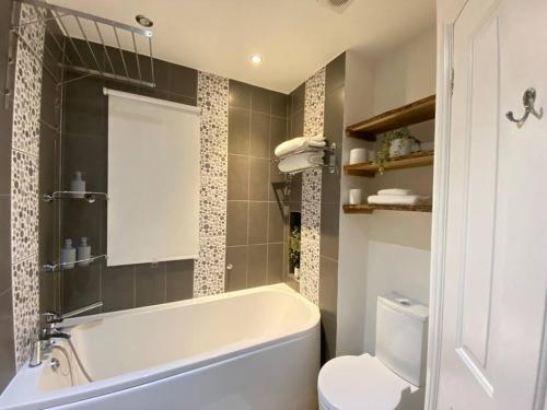 珀弗利特Spacious 2 bed flat ideal for long stays的浴室配有白色浴缸和卫生间。