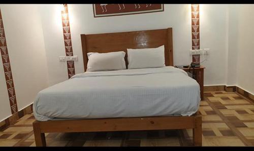 穆索里FabHotel Rudraksh Resort的一间卧室配有一张大床和木制床头板