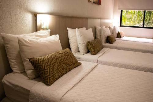 伊瓜苏伊瓜苏快捷酒店的配有白色枕头的酒店客房内的两张床