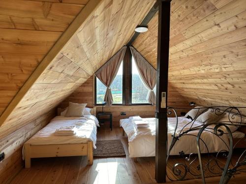 SopotOzoni & Sauna的阁楼卧室设有两张床铺和木墙