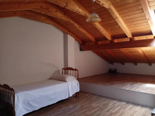 RipaVilla ILIRIA的一间卧室设有一张床和木制天花板