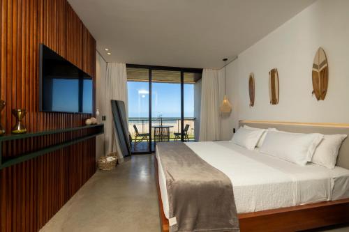 圣米格尔-杜戈斯托苏Nanii Hotel的一间卧室配有一张床、一台电视和一个阳台
