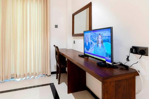 米瑞莎Coastal Villa Mirissa的一间配备有书桌的客房,配备有一台电视。