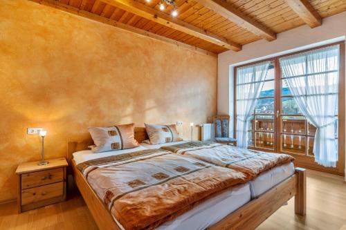 SchuttertalWanglerhof Familie Wangler的一间卧室设有一张大床和一个大窗户