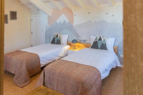 塞亚Chão do Rio - Turismo de Aldeia的一间带两张床的卧室和山壁画