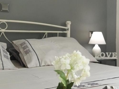 海若克利欧Grey Sense Luxury Apartment的一张白色的床,桌子上放着花瓶