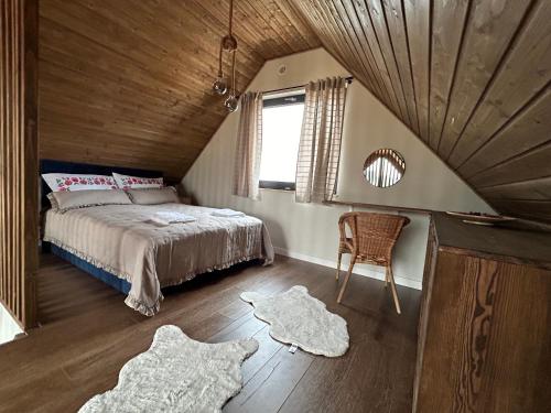 ŚciegnyREST ZONE - mountain holiday chalets的卧室配有床、椅子和窗户。