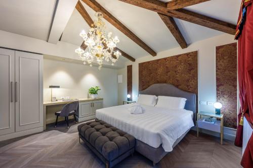 威尼斯Hotel Palazzina Sardi的一间卧室配有一张床、一张书桌和一个吊灯。