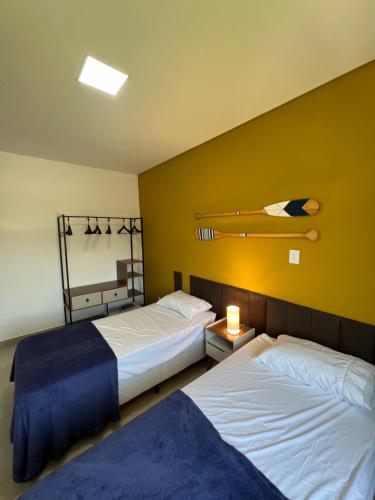 帕拉蒂Casa Beija-Flor的黄色墙壁客房的两张床
