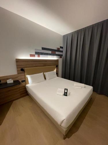 普拉托B&B HOTEL Prato City Center的一间卧室配有一张带时钟的床