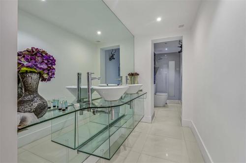伦敦Earls Court Spacious Apartment的浴室设有两个水槽和花瓶
