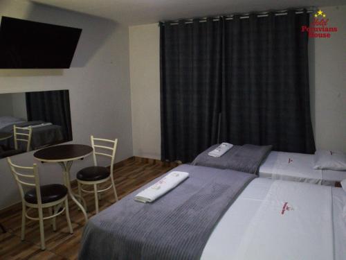 利马Hotel Peruvians House的卧室配有一张床和一张桌子及椅子