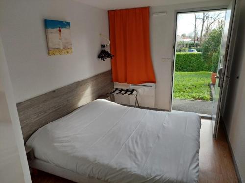 桑特Premiere Classe Saintes的一间卧室配有床和橙色窗帘的窗户