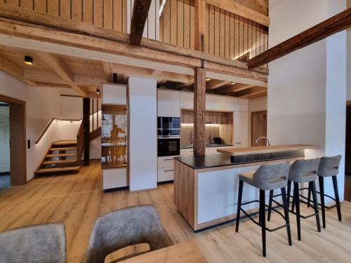 大基希海姆das MARX - Gasthof Marx - Apartments的开放式厨房设有木制天花板和木凳