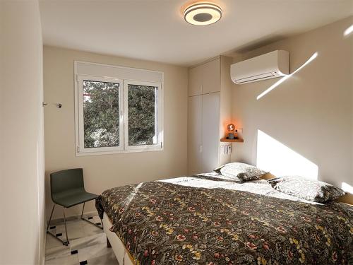 米哈斯科斯塔Beachfront apartment Mijas Costa - Marbella的卧室配有床、椅子和窗户。