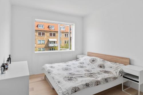 哥本哈根Modern Central Located Apartment的白色的卧室设有床和窗户