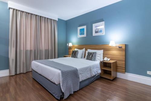 圣保罗Gran Villagio Hotel SP by Castelo Itaipava的一间卧室配有一张带蓝色墙壁的大床