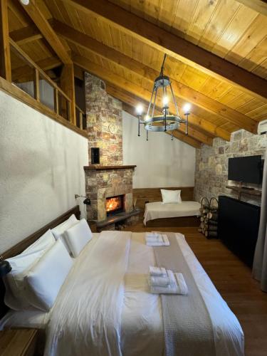 沃斯科波亚Hotel Ambassador Voskopojë的一间卧室设有一张大床和一个壁炉