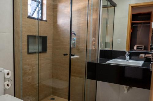 瓜拉普阿瓦Adria Premium Hotel的带淋浴和盥洗盆的浴室