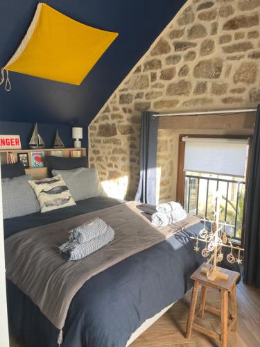 普罗梅尔Gîtes d'Izel n°2的一间卧室设有一张大床和石墙