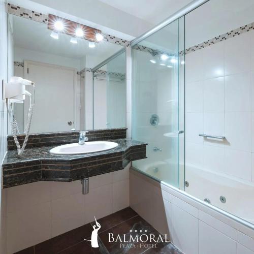 蒙得维的亚BALMORAL Triple SUITES的一间带水槽和玻璃淋浴的浴室