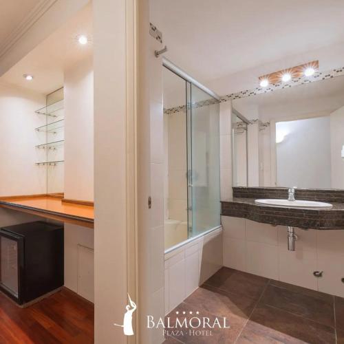 蒙得维的亚BALMORAL Triple SUITES的一间带水槽和玻璃淋浴的浴室