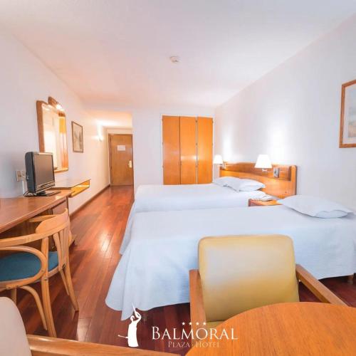 蒙得维的亚BALMORAL Triple SUITES的酒店客房配有两张床和一张书桌