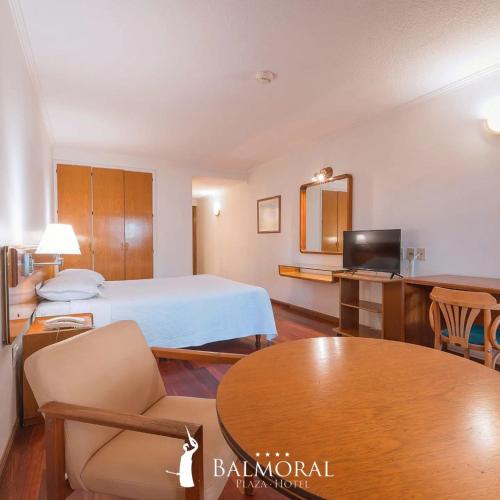 蒙得维的亚BALMORAL Triple SUITES的酒店客房配有一张床铺和一张桌子。