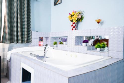 洛美EKA ELITE HOTEL的白色的厨房,配有水槽和花卉台面