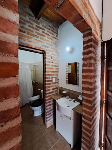 蒂尔卡拉Kurpachana cómodos departamentos a 3 cuadras de la plaza.的砖砌浴室设有水槽和卫生间