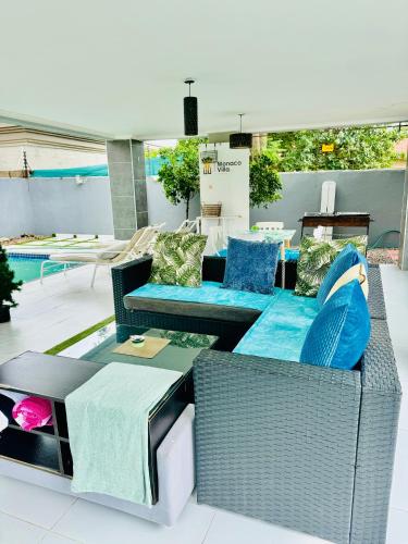 哈博罗内Monaco villa Gaborone的一个带柳条家具和游泳池的庭院