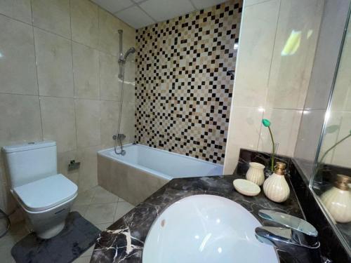 迪拜Elite LUX Holiday Homes - Two Bedroom Apartment Direct Metro Access in Al Furjan, Dubai的带浴缸、卫生间和盥洗盆的浴室