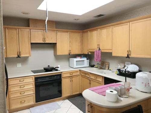 拉斯维加斯Super bedroom with private bathroom 5的厨房配有木制橱柜和炉灶烤箱。