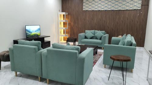 伊斯兰堡Bloom Rooms的客厅配有蓝色椅子和电视