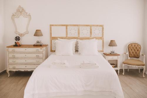 雷根古什-迪蒙萨拉什Casa Coração Alentejano- Casas com EnCanto的卧室配有白色床、梳妆台和椅子