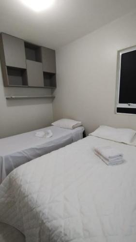 若昂佩索阿APARTAMENTO JOÃO PESSOA BESSA的带电视的客房内的2张白色床