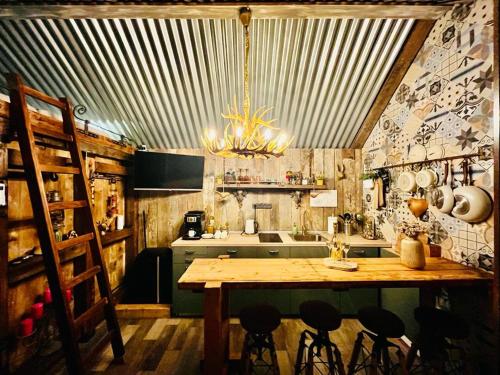 耶什赫维采Tiny House Všemily的厨房配有一张大木桌和吊灯。