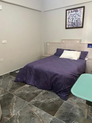 伊斯坦布尔Zerya suites的一间卧室配有一张带紫色床单的床和一张桌子