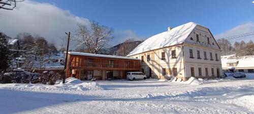 梅图耶河畔特普利采Apartment Ve Mlýně的旁边一座大建筑,地面上积雪