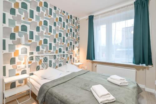 格丁尼亚Willa LTC Apartments Orłowo的一间卧室配有一张床,上面有两条毛巾
