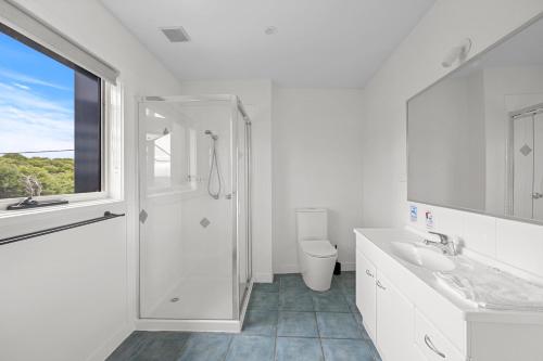 桑迪角Sandy Point Beach Escape 2 Bedroom Apartment的带淋浴和盥洗盆的白色浴室
