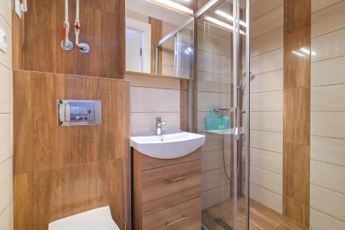 格丁尼亚Willa LTC Apartments Orłowo的浴室配有卫生间、盥洗盆和淋浴。
