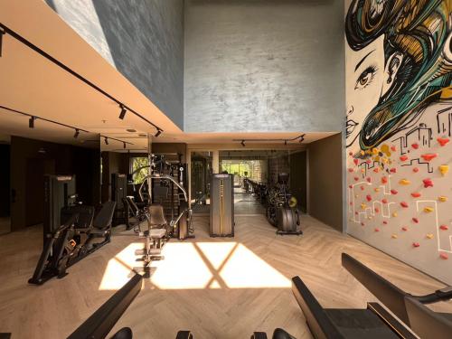 圣保罗Iconyc Charlie Hotel São Paulo - Soft Opening的健身房设有有氧器材和壁画
