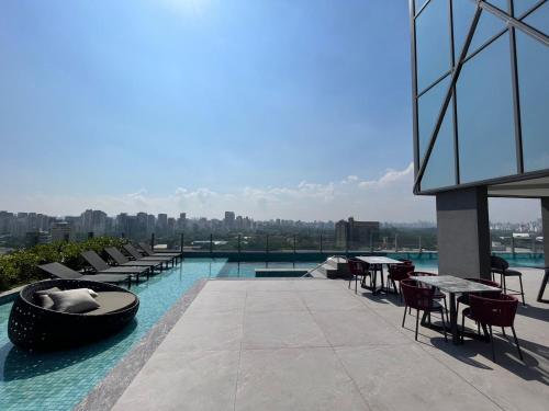 圣保罗Iconyc Charlie Hotel São Paulo - Soft Opening的大楼内一个带桌椅的游泳池