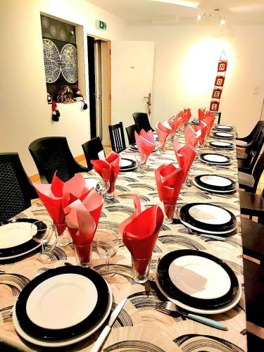 昂热L'auberge Angevine的长桌,带红椅子和盘子,酒杯